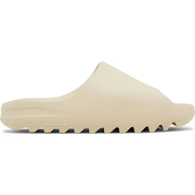 Beige Adidas Yeezy Slide Bone foam sandal with a ridged sole for comfort and style