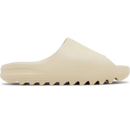 Beige Adidas Yeezy Slide Bone foam sandal with a ridged sole for comfort and style