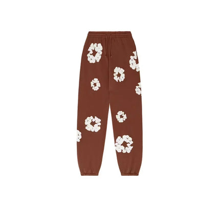 Brown floral patterned sweatpants from Denim Tears with Nike Dunk and Jordan 4 pairing