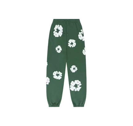 Green sweatpants with white floral pattern from Denim Tears The Cotton Wreath collection featuring Nike Dunk style