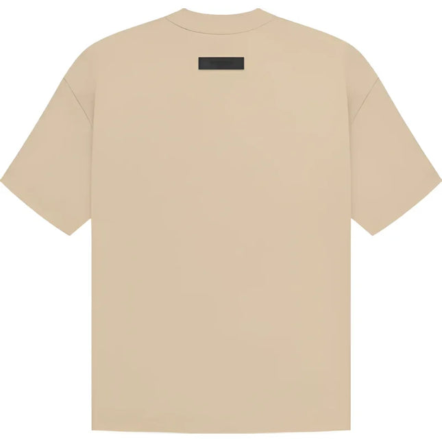 Beige Fear of God Essentials SS Tee featuring a small black rectangle tag on the back