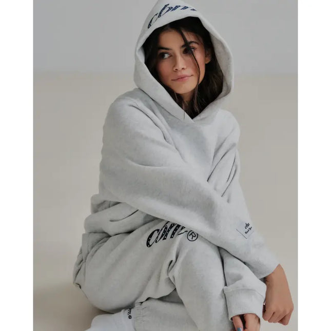 Woman in a gray hoodie and sweatpants, the perfect blend for Nike Dunk style