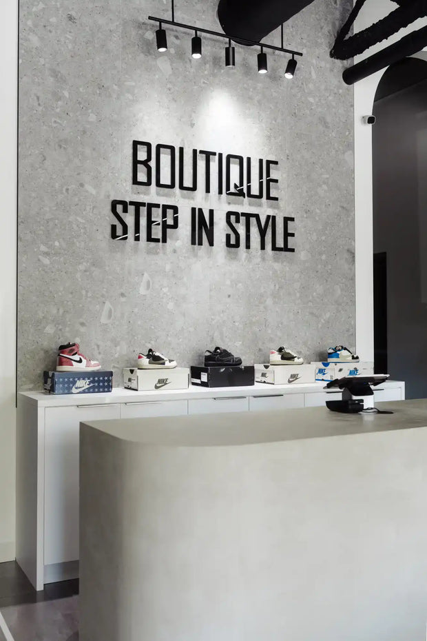 Boutique shoe display featuring various sneakers on a white counter.