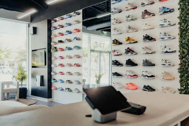 Wall display of various colorful sneakers and athletic shoes.